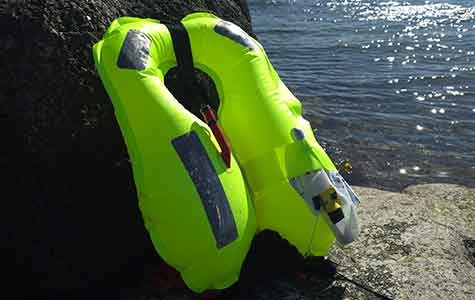 A triggered and inflated life jacket placed near the ocean.