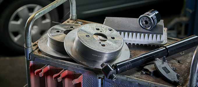Close-up of car spare parts lying on a workshop trolley in a workshop.